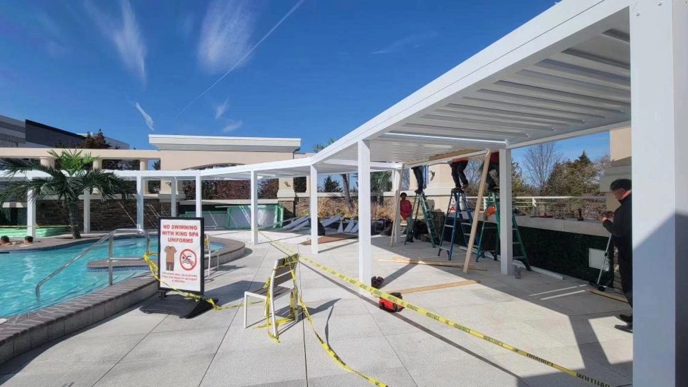 Large white motorised pergola by swimming pool in USA backyard