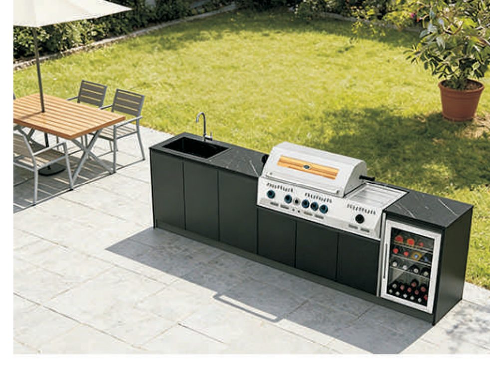 Freestanding black outdoor kitchen on garden lawn